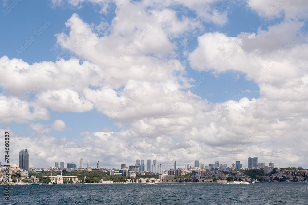 panoramic view of the skyline of the financial center of Istanbul seen from the Bosphorus, with the Dolmabahce palace under a cloudy sky, copy space