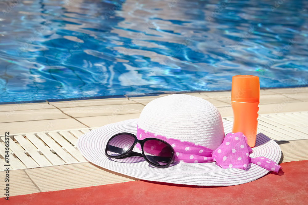 beautiful hat near the pool with cream and glasses background