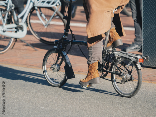 Person Riding Folding Bicycle in the City