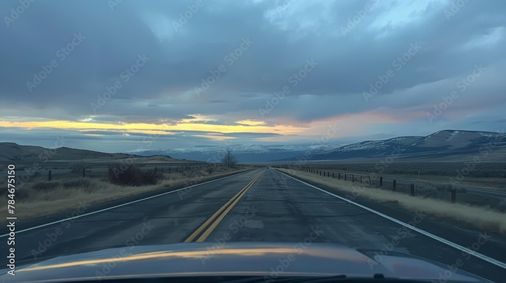 Empty road with mountain views seen through the front windshield of a car. generative ai