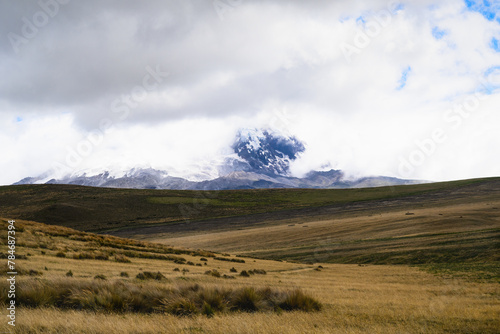 Antisana volcano with ice and snow on sunny day with blue sky and white clouds. Landscape in Ecuador 