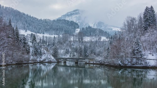 Time lapse, snowy mountain landscape near lake in the Swiss Alps. Lake Stausee. Vorderthal, canton of Schwyz, Switzerland. photo