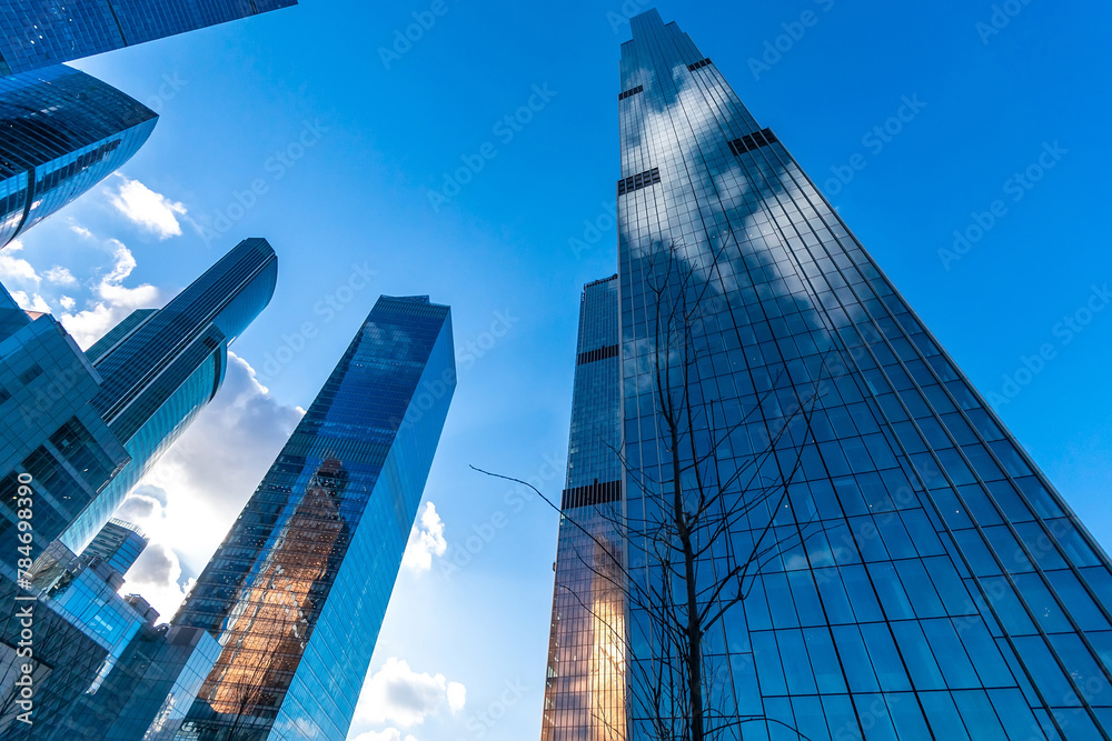 A cluster of tall buildings standing next to each other in a busy urban environment. The skyscrapers create a modern and bustling cityscape, with each structure vying for attention A cluster of tall buildings standing next to each other in a busy urban environment. The skyscrapers create a modern and bustling cityscape, with each structure vying for attention