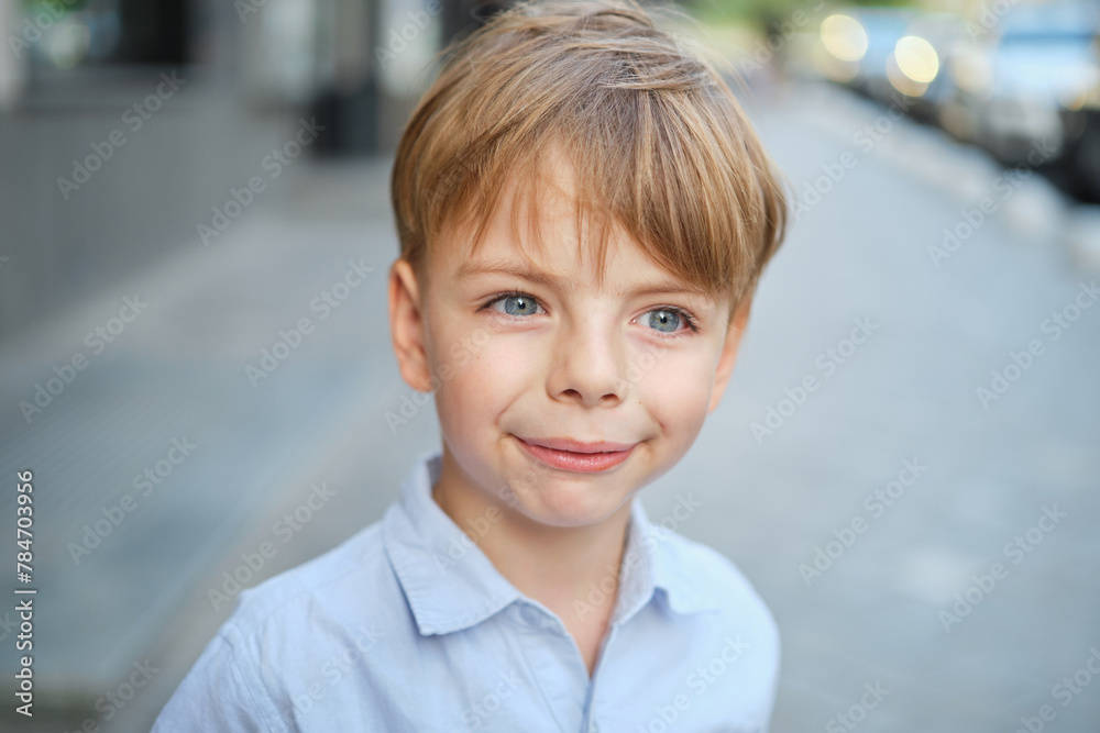Handsome smiling little boy on the sunny urban background . Close-up portrait. Blond hair, blue eyes , 9 years boy smiling, having fun in the city. High quality photo Handsome smiling little boy on the sunny urban background . Close-up portrait. Blond hair, blue eyes , 9 years boy smiling, having fun in the city. High quality photo