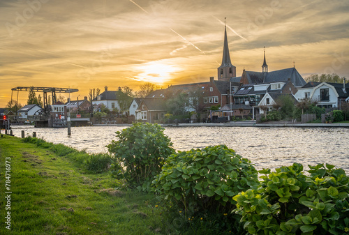 Dutch village of Koudekerk aan den Rijn and Oude Rijn river by sunset photo