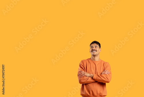 Smiling man in orange sweater on yellow