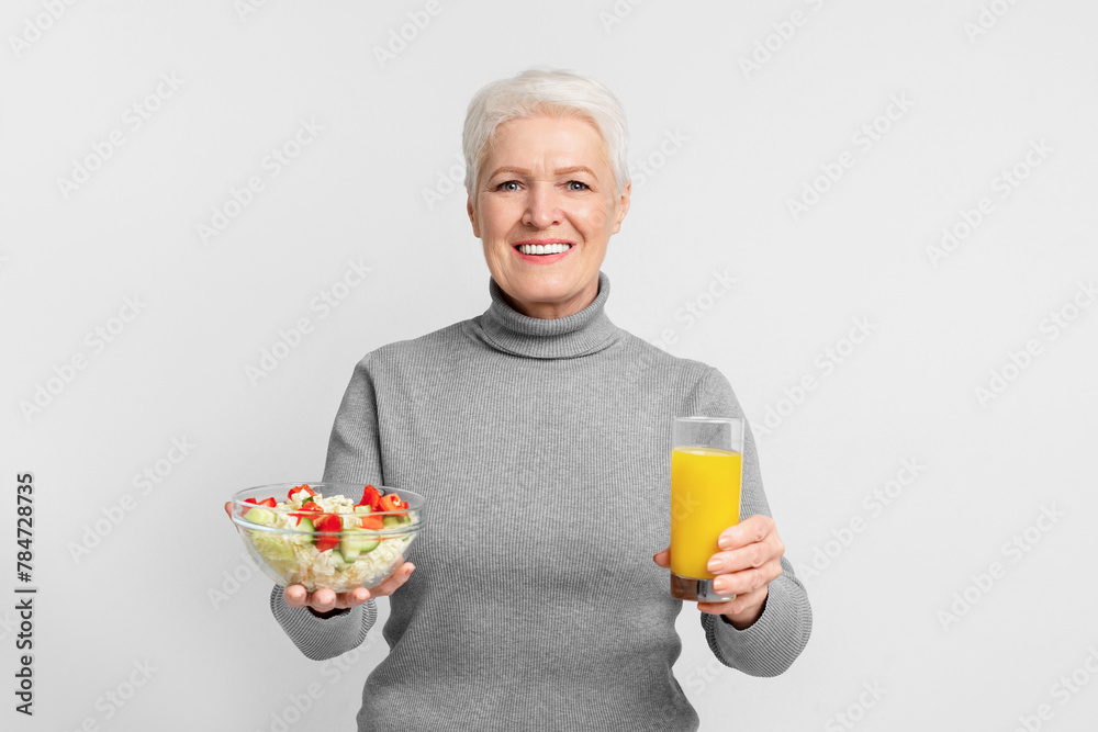 Senior woman with salad and orange juice smiling Senior woman with salad and orange juice smiling