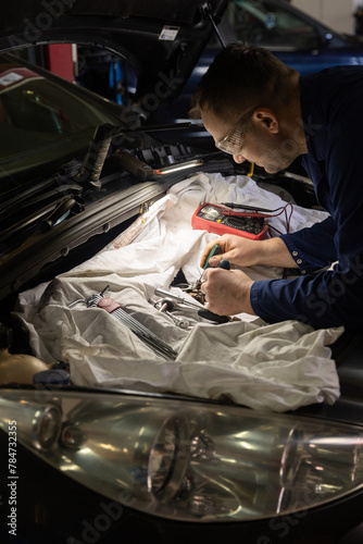 Male mechanics at the garage fixing a car