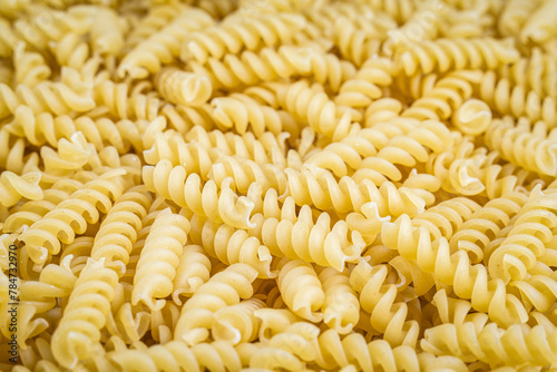 A pile of raw italian fusilli spiral pasta. Texture background.