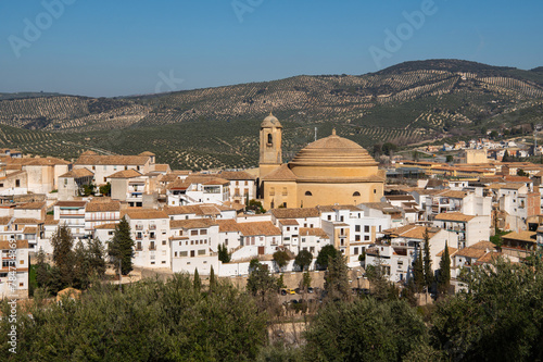 Church of the Incarnation or Iglesia de la Encarnacion and white houses under cloudless sky. Pueblos blancos, Andalusia, Spain. Spanish white village. Old town Montefrio. photo