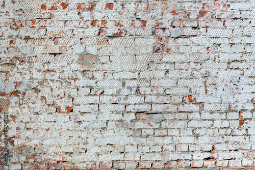 Old red brick wall with peeling plaster.. 
