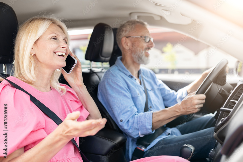 Senior woman on phone call in car, man happily driving