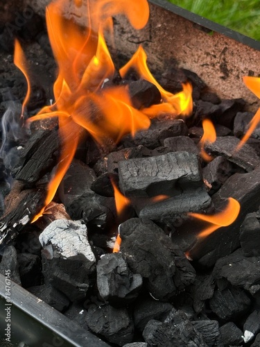 Vertical close up of fire flames in charcoal bbq grill