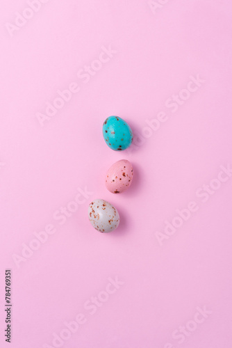 Chocolate colored Easter eggs speckled on a pink background. Minimalism Easter concept, copy space