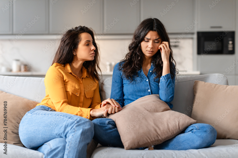 Young lady soothing a friend with a headache Young lady soothing a friend with a headache