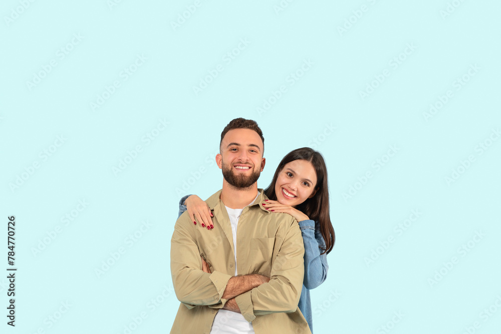Happy couple posing with a hug on blue background Happy couple posing with a hug on blue background