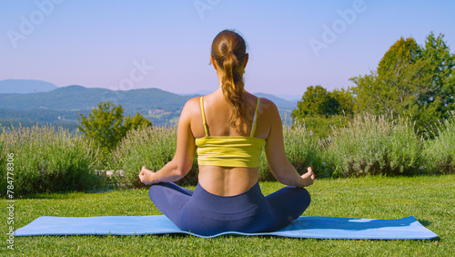 Female person during a yoga meditation in a peaceful garden with stunning view