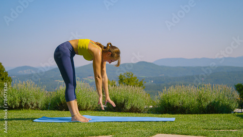 Poor forward bend flexibility for a young woman learning a basic yoga routine photo