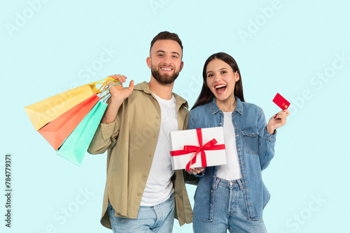 Happy couple with shopping bags and gift photo