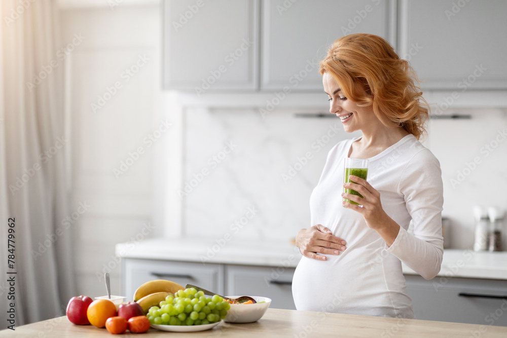 Pregnant woman with healthy kitchen foods, copy space