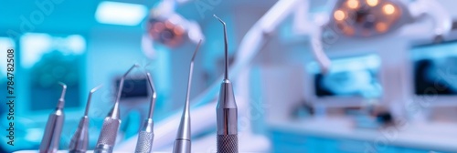 A dentist is holding a pair of dental instruments in a blue glove. The instruments are silver and appear to be used for cleaning teeth. Concept of professionalism and cleanliness in a dental setting photo