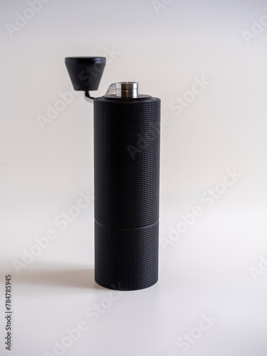 close-up of a black metal manual coffee grinder. Tool for making coffee. White background