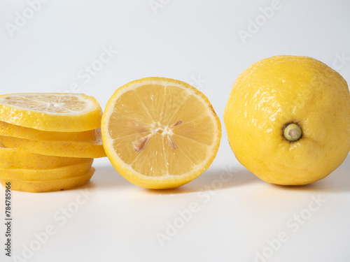 Close-up of a cut and whole lemon lying on a white background. isolated fruit. Sour yellow fruit full of vitamins. Side view