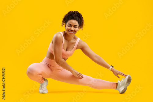 Energetic black woman doing a fitness side lunge