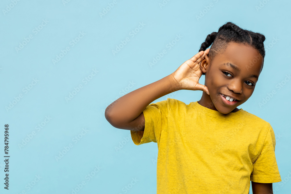 Smiling African American little boy with hand near ear Smiling African American little boy with hand near ear
