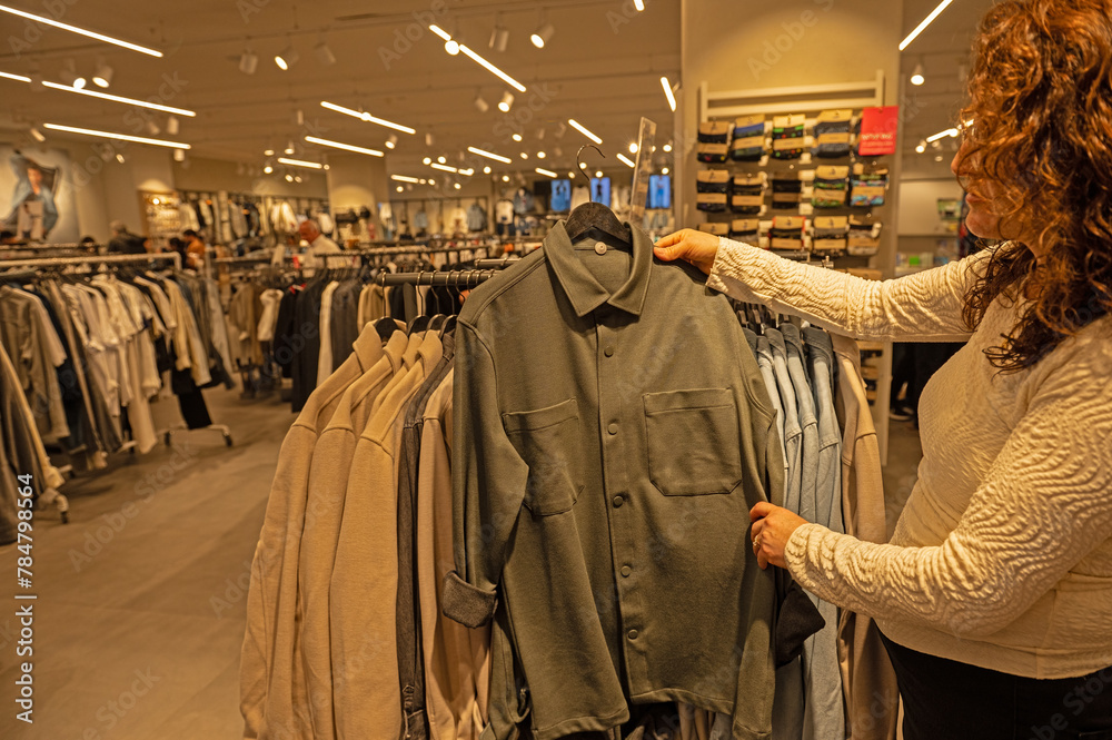 Woman examining clothes in a clothing store.