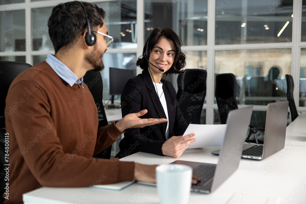 Office employees in headset using laptop for work in coworking space