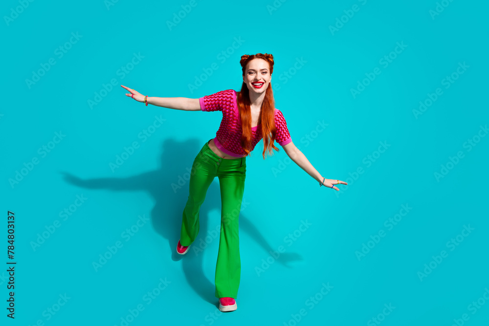 Obraz premium Full length photo of excited funky lady dressed pink knitted shirt having fun emtpy space isolated blue color background
