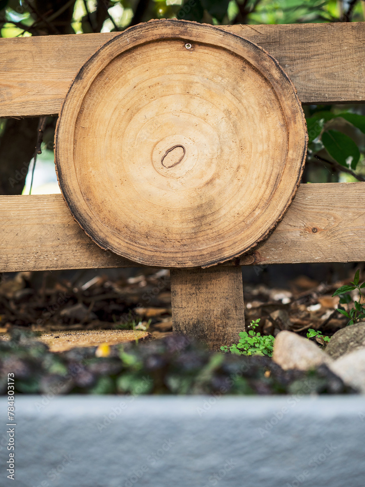 Wood log slice as element of decoration on a wooden fence. Using natural material to create Earth mood style design.