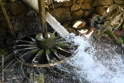 Traditional watermill on the river. Old water mill wheel. Hydropower. Water splashing. 