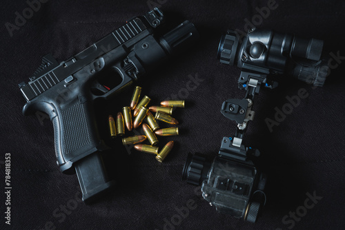 Military night vision device and tactical pistol with flashlight and red dot and 9mm cartridges.