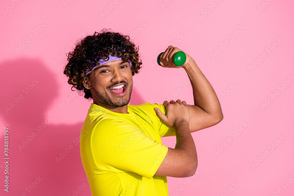 Photo of positive strong nice man wear trendy yellow clothes showing muscular arm triceps isolated on pink color background Photo of positive strong nice man wear trendy yellow clothes showing muscular arm triceps isolated on pink color background