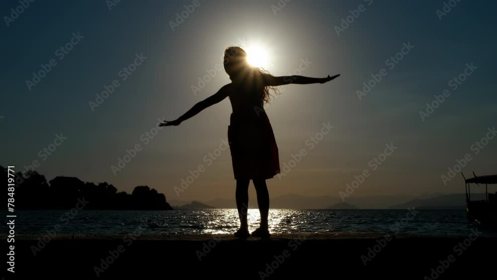 Child enjoy lovely nightfall lake. A silhouette of playful teen girl silhouette resting in sunset sea wind during summer weekend. Child enjoy lovely nightfall lake. A silhouette of playful teen girl silhouette resting in sunset sea wind during summer weekend.
