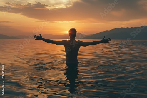 Silhouette of a man is in the water, arms raised with beautiful dawn light. Summer vacation concept, background © top images