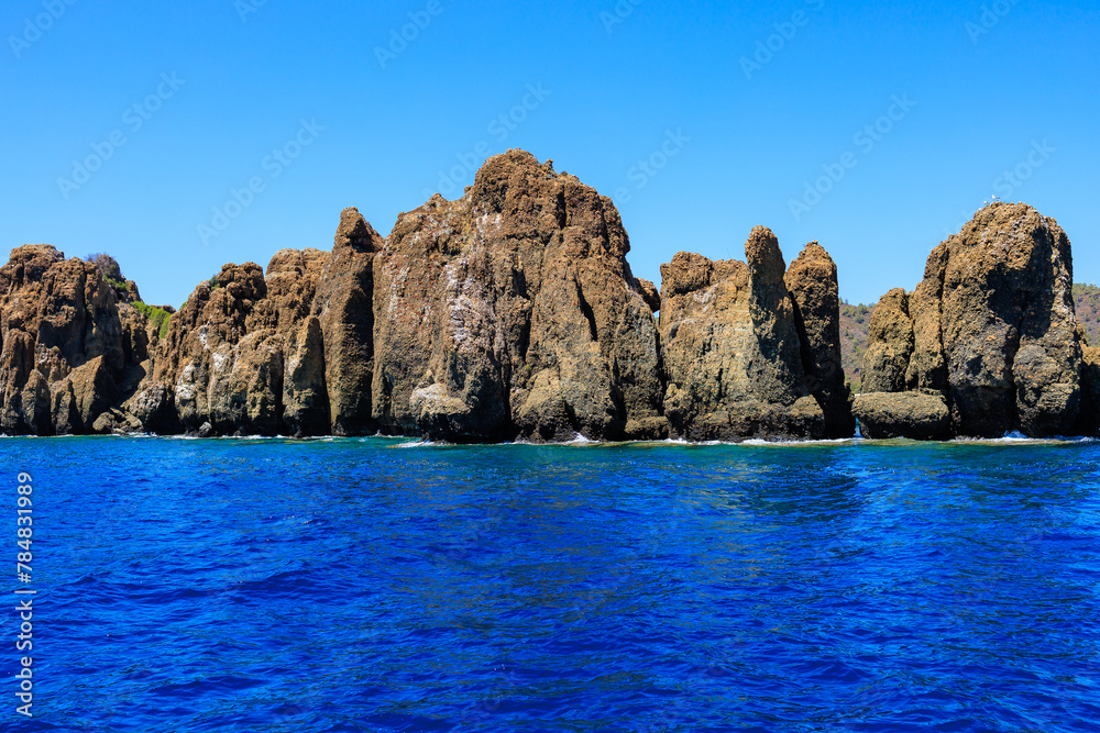 Rocky coast in the resort part of the Mediterranean or Aegean Sea. Background with selective focus and copy space Rocky coast in the resort part of the Mediterranean or Aegean Sea. Background with selective focus and copy space