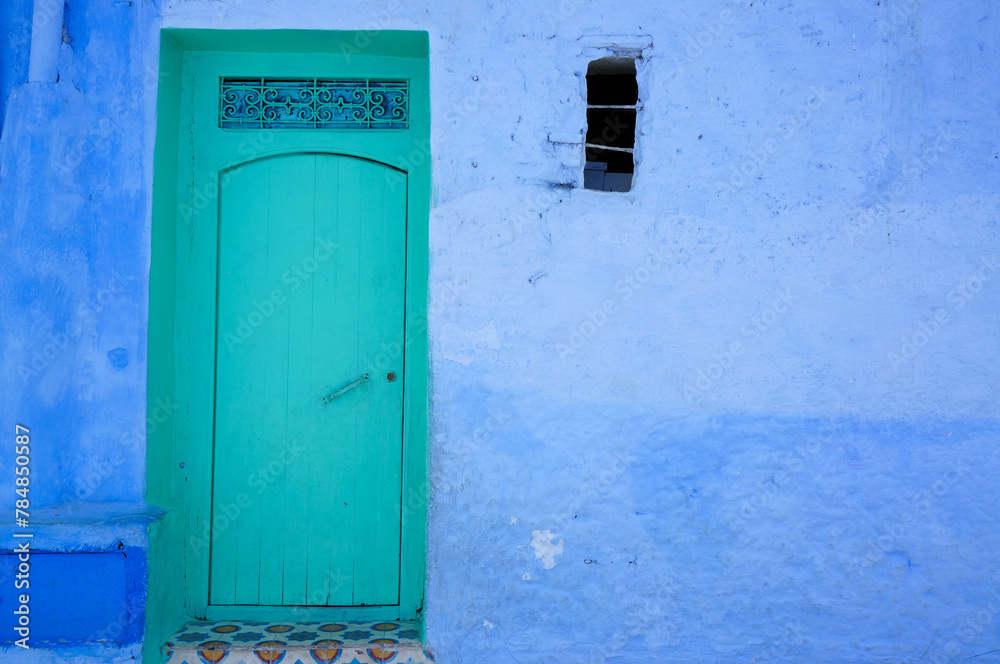 青い壁に映えるエメラルド色の扉