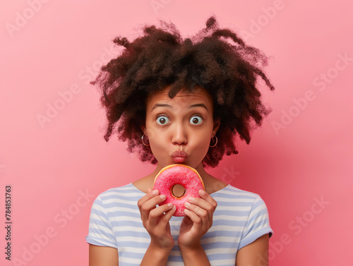 Uma jovem em fundo rosa, segurando uma rosquinha em uma mão e uma maçã na outra, refletindo sobre nutrição, saúde dieta e escolhas alimentares photo