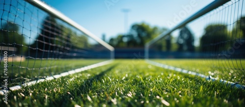 Soccer net on the green grass of a soccer field. The net is in focus photo
