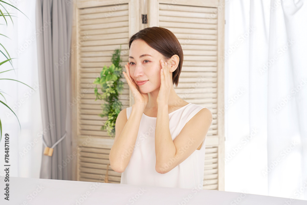 自宅でスキンケアをする40代の女性 自宅でスキンケアをする40代の女性