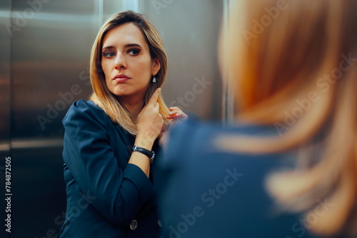 Professional Woman Arranging her Hair in an Elevator Mirror. Businesswoman caring for her physical appearance being a perfectionist
