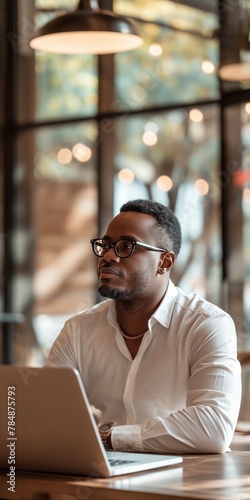 Vertical portrait of African American entrepreneur in a cafe setting, showcasing modern business casual attire.