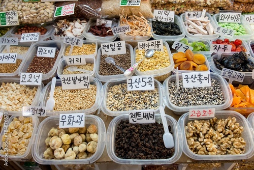 A variety of nuts and seeds are displayed in plastic containers food grain market sell photo