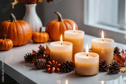 Beautiful burning candles on the table in a living room with autumn decoration.