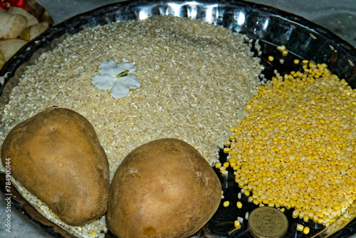 raw rice potato pulses arranged in a steel plate as an offering for Hindu puja in India photo