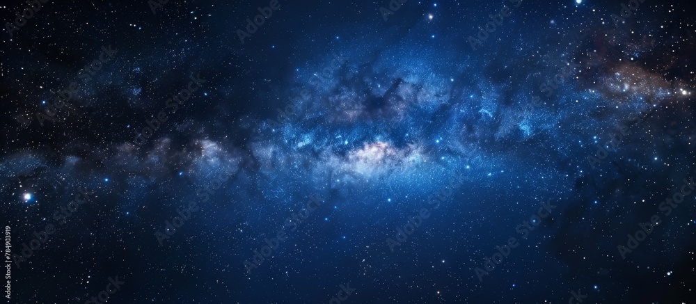 A serene night sky with a deep blue hue scattered with numerous stars and a striking bright blue center