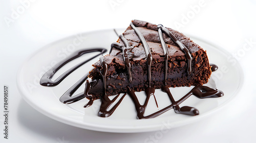 a piece of brownie cake with melted chocolate on a white plate on a white background